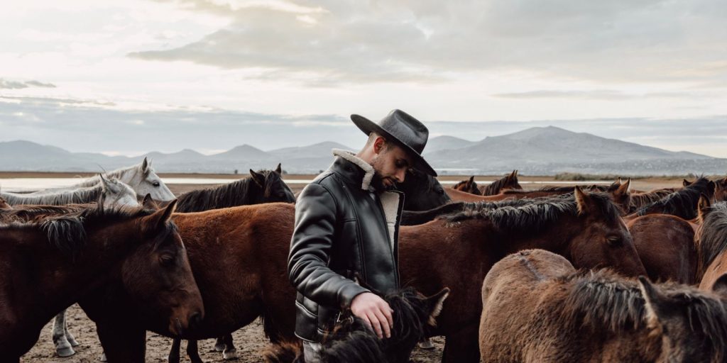 Une silhouette en cuir western robuste devant un paysage ouvert