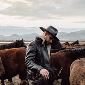 Une silhouette en cuir western robuste devant un paysage ouvert