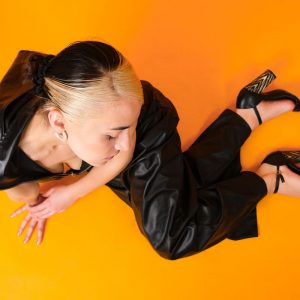 Une mannequin en cuir noir sur un fond de studio audacieux