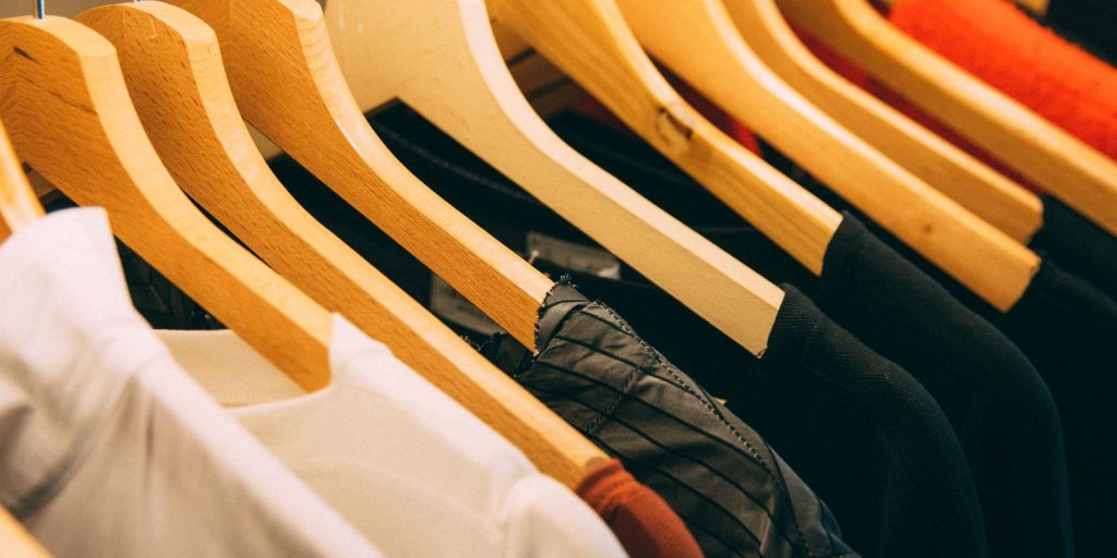 Rangée de vestes suspendues sur des cintres en bois dans un dressing