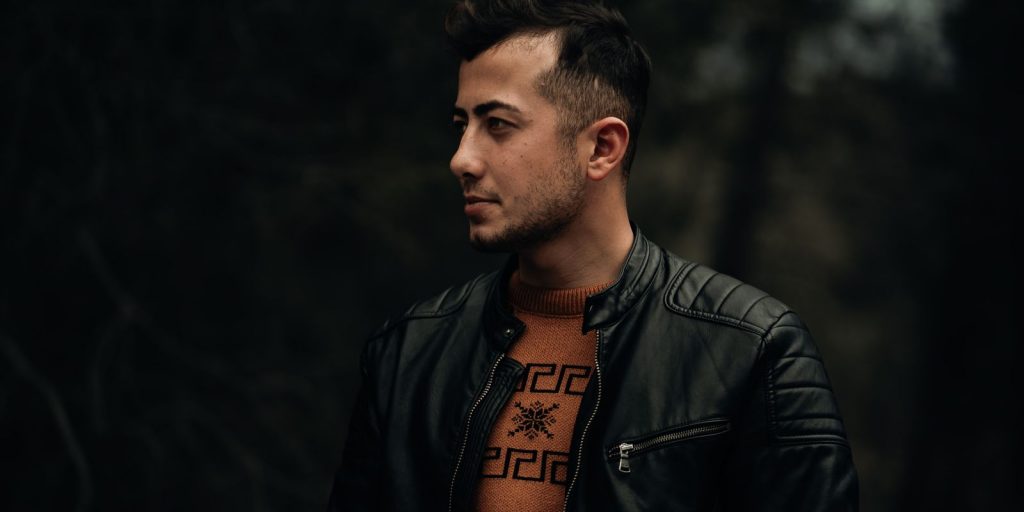 Portrait de profil d'un homme en blouson de cuir noir sur fond sombre